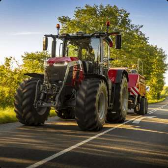 ciągnik massey ferguson w trakcie jazdy na drodze